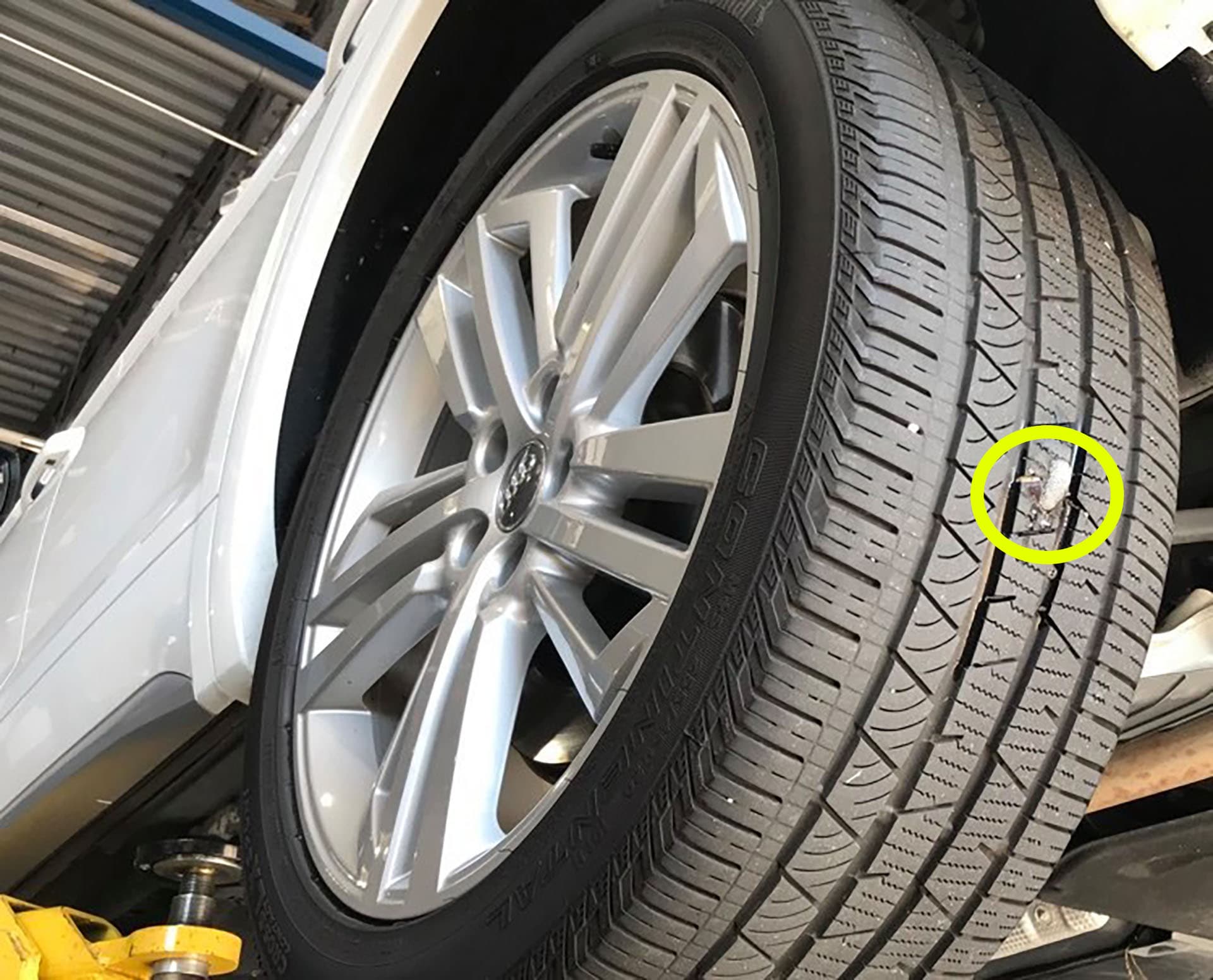 Monteur van Mobiele Banden Specialist beoordeelt een schroef in het loopvlak van een band